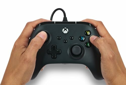 Hands holding a black gaming controller.