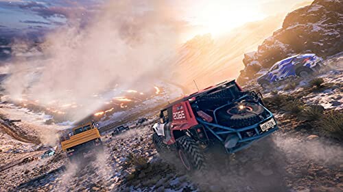 Off-road vehicles racing on rocky terrain at sunset.